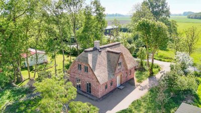 Wohnen mit Geschichte – Neubau unter Reet am Eiderdeich