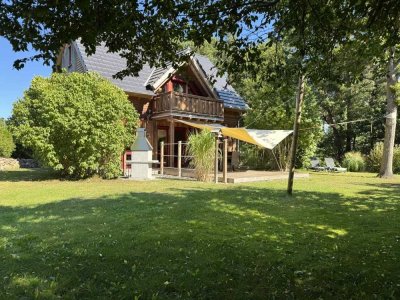 Natürlich gebautes Haus mit Luftwärmepumpe und Holzschuppen