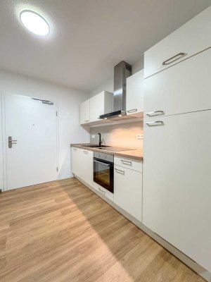 NEUBAU! LICHTDURCHFLUTETE 1-ZIMMERWHG. MIT EINBAUKÜCHE UND BALKON + PKW-STELLPLATZ