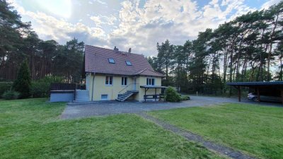 Ein Einfamilienhaus am Waldesrand, in ruhiger Lage mit grünen Grundstück und Carport.