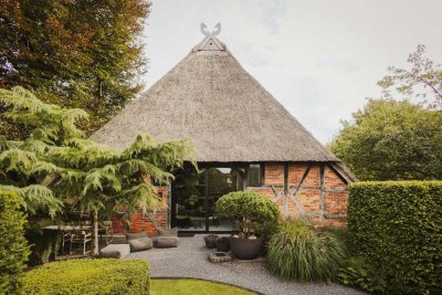 Spektakuläre, moderne Architektur unter Reet: die Räucherkate von Poggensee