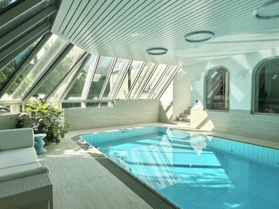Riesige Familienvilla mit Poolhalle auf Gartenebene mit großer Garage