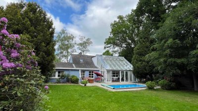 Eine Wohnoase mit Wintergarten, Pool & großem Garten