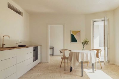 Zeitlos nordisch: Sandbeige Küche, warmes Parkett & Südwestbalkon ins Grüne