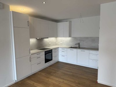 Erstbezug 3 Zimmerwohnung mit Balkon, Stellplatz und Einbauküche. Erdwärmepumpe A+ ab 01.07..