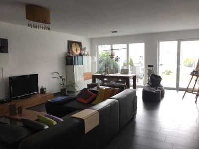 Moderne Wohnung mit überdachter Terrasse und kleinem Garten