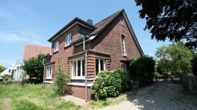 Freistehendes Einfamilienhaus mit Garage und großem (Bau-)Grundstück.
