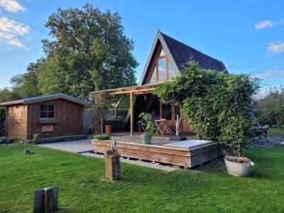 Nurdachhaus im Park mit See