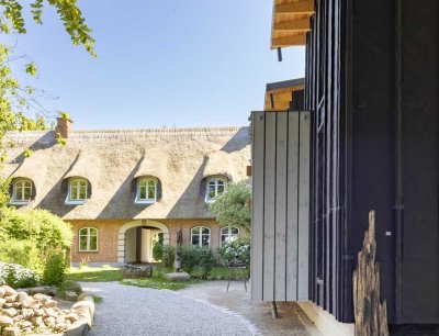 Traditionelle Gemütlichkeit: Reetdach-Doppelhaus auf idyllischem Pfeifengrundstück