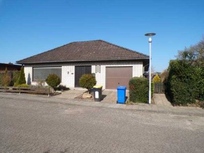 Walmdachbungalow mit innenliegender Garage und Holzgartenhaus